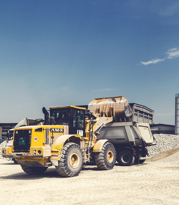 a photo of a yellow and brown metal pay loader on the dirt
